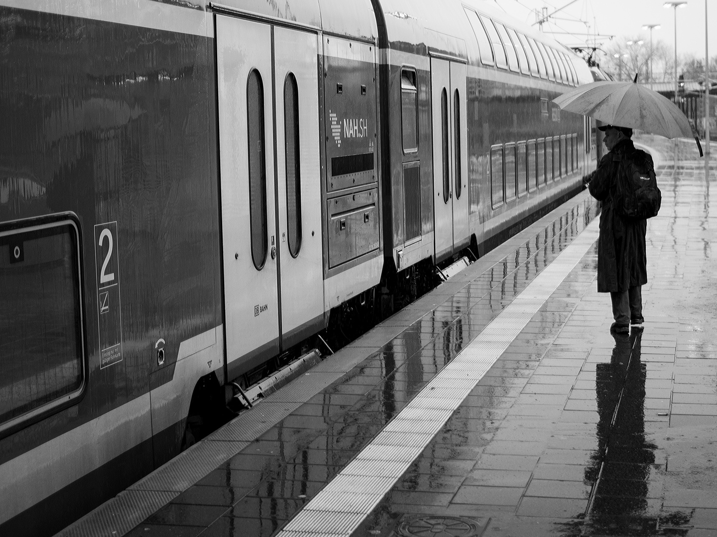 im Regen auf dem Bahnsteig