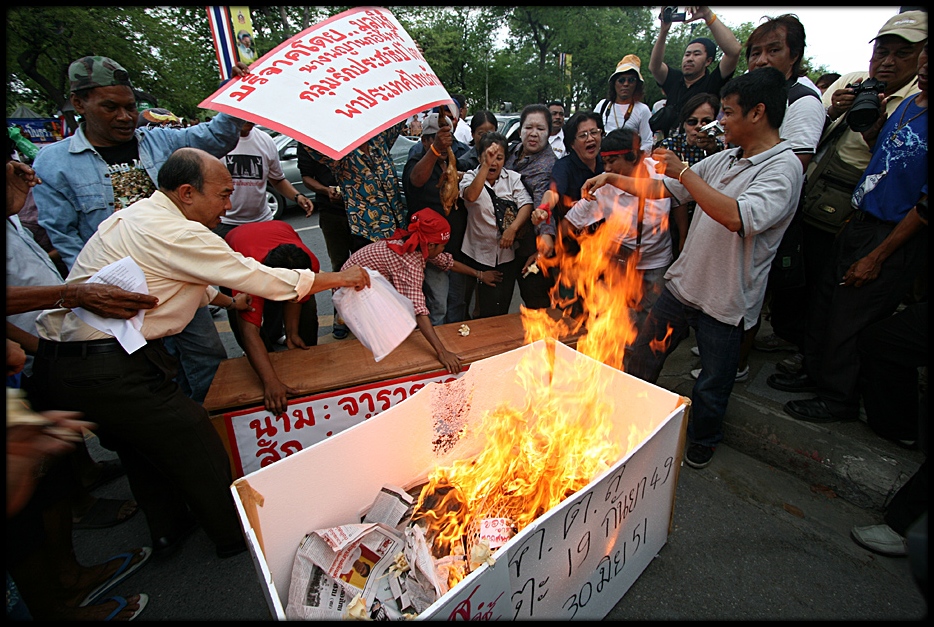 In Bangkok demonstrators von die Roten zeigen was sie halten von press reports von die Gelben :-(