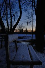 In einer kalten Winternacht auf einer Bank am See ...