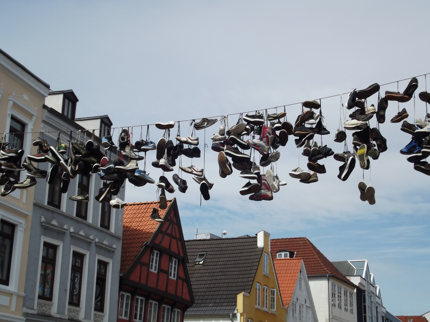 In Flensburg in der Norderstraße hängen die Schuhe hoch in der Luft.