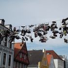 In Flensburg in der Norderstraße hängen die Schuhe hoch in der Luft.