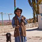 Indio-Frau mit Hund im Altiplano