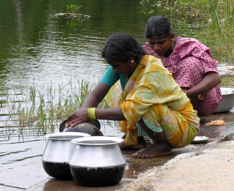 Indische Frauen beim Geschirrspuelen