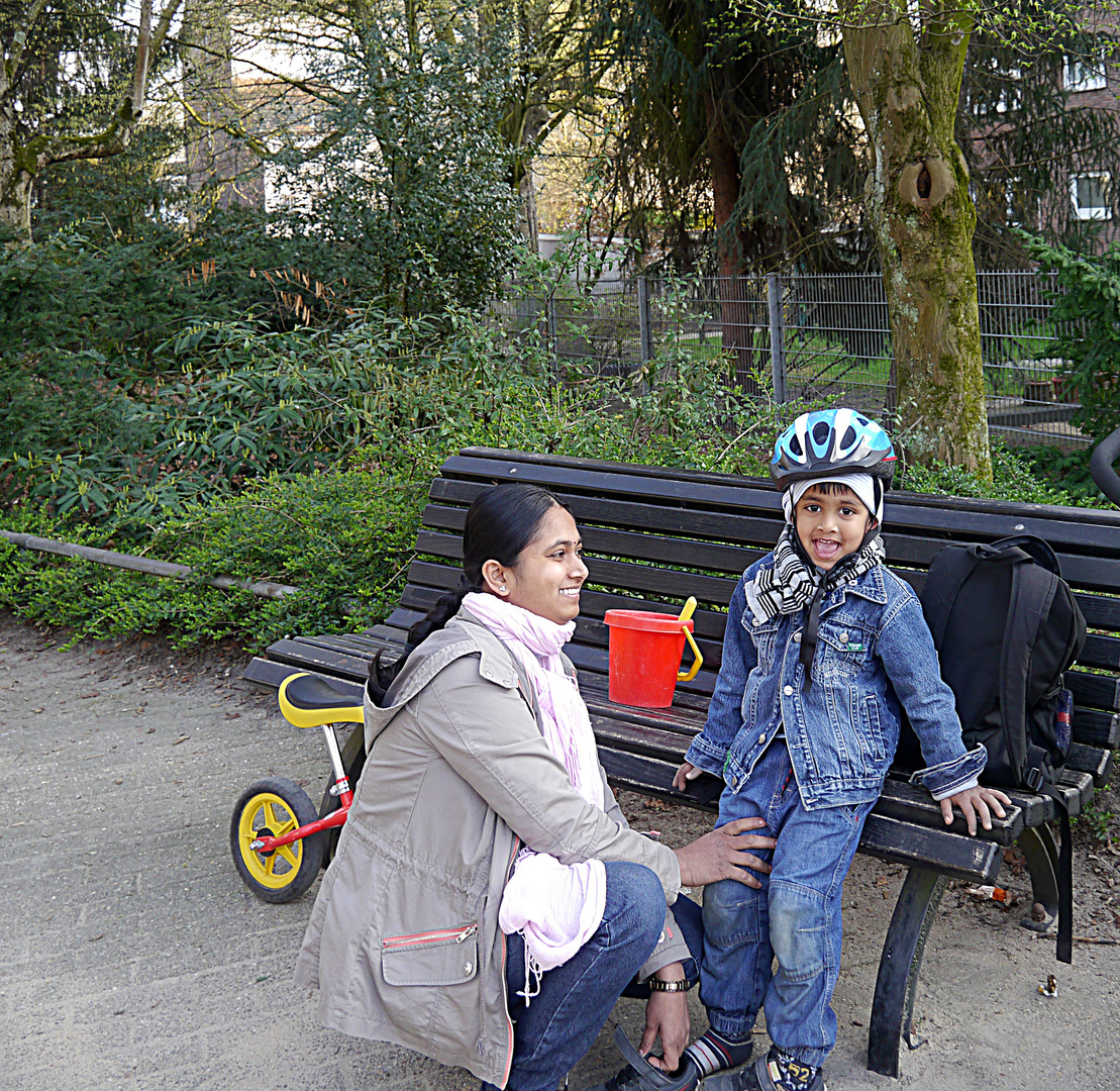 Indische Mutter mit ihrem kleinen Sohn auf dem Spielplatz.