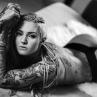 Inked girl on her bed.