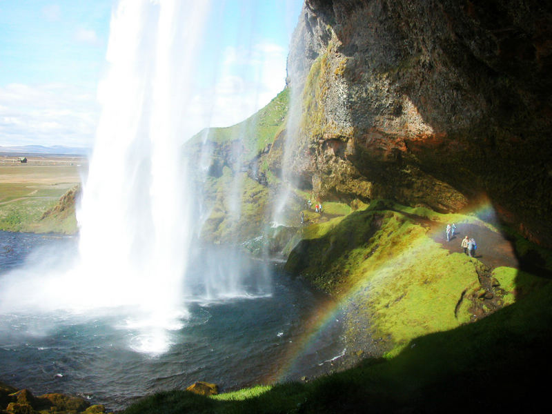 ISLAND Seljalandfoss von hinten mit Regenbogen