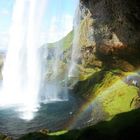 ISLAND Seljalandfoss von hinten mit Regenbogen