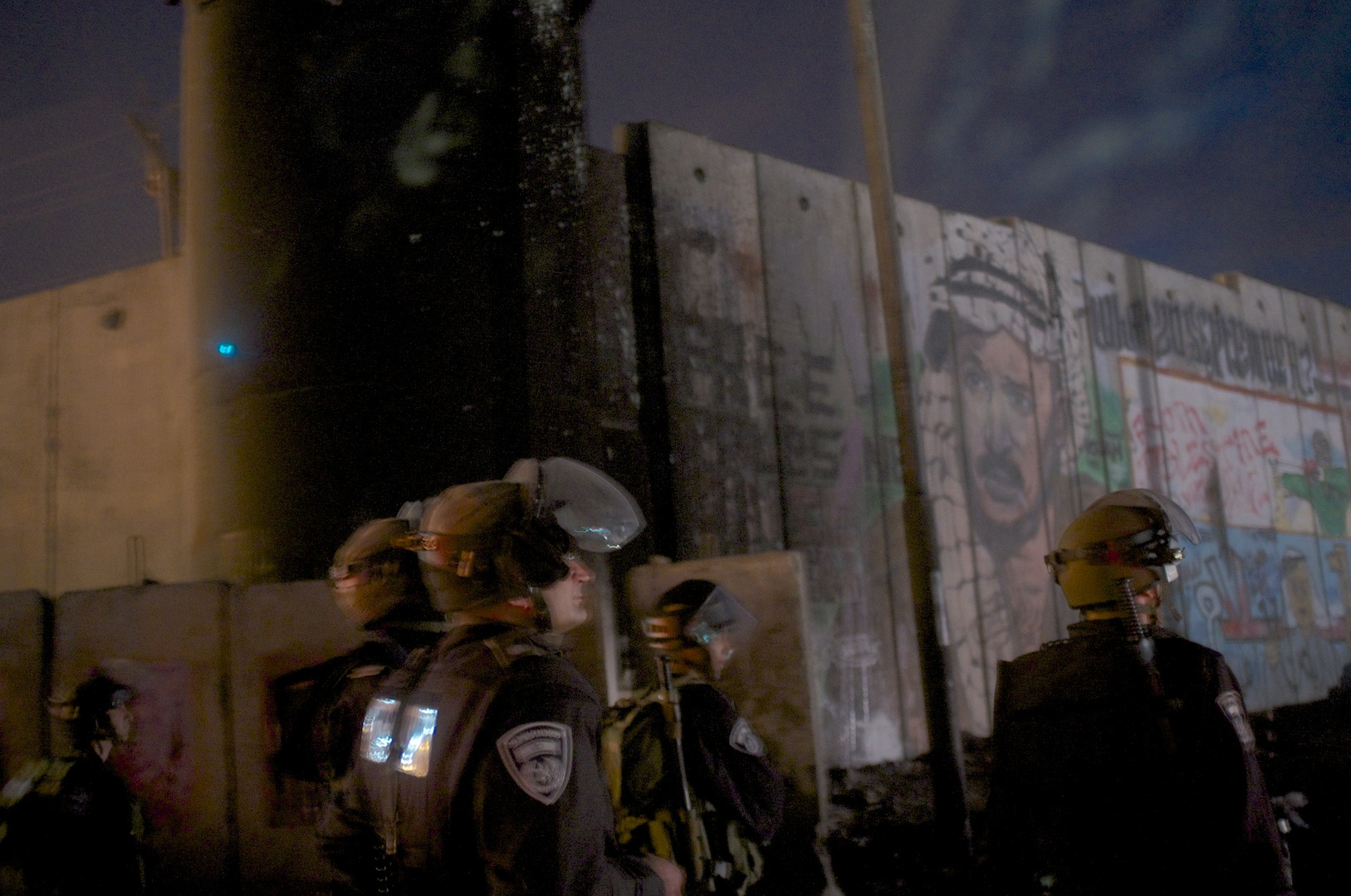 Israeli soldiers in Riot Gear as Arafat looks on from the separation wall