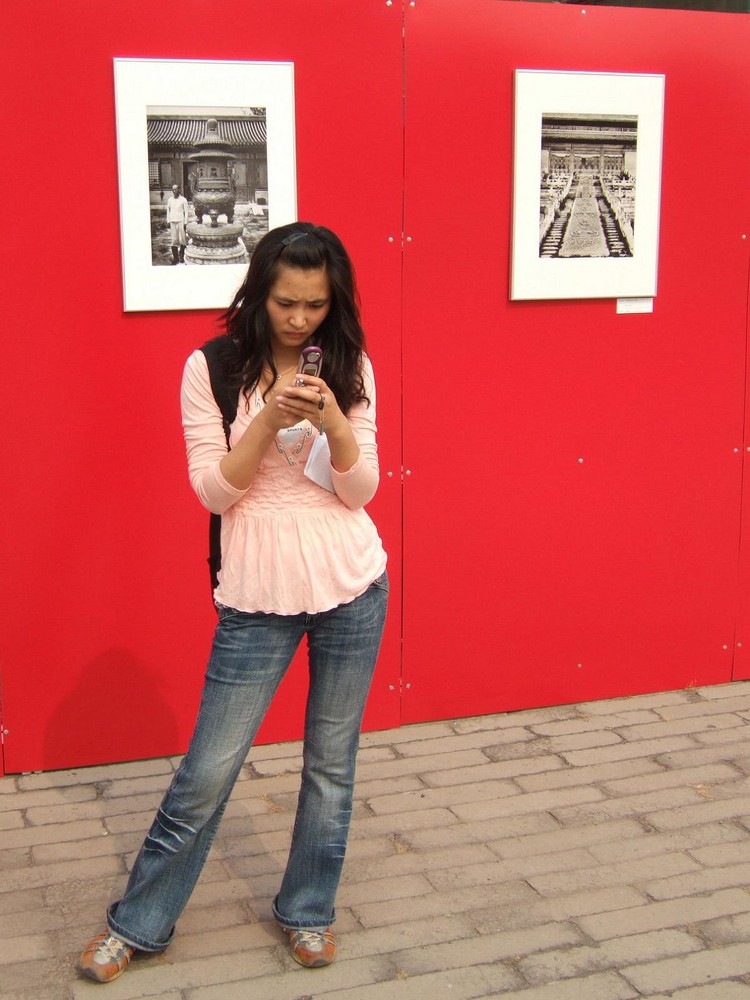 jeune chinoise au téléphone devant la cité impériale à Pékin.