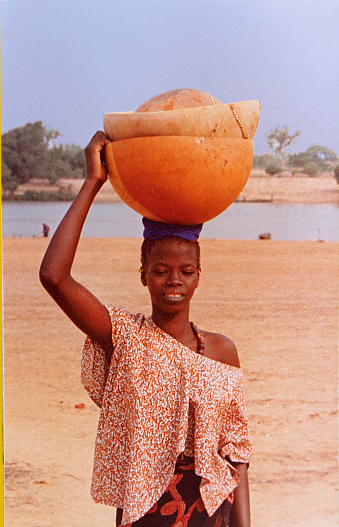 Jeune malienne porteuse de calebasses au bord du Niger