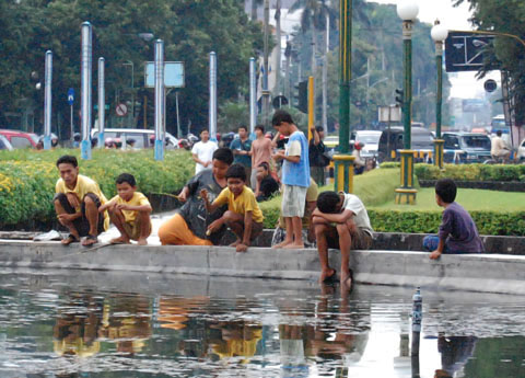 Jugendliche an einem Brunnen in Indonesien