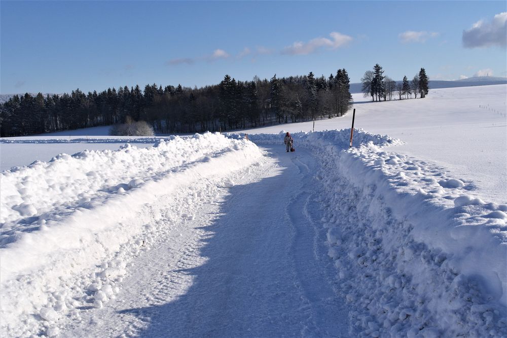 Jugendlicher Schneeräumer und rechts der Schneeberg im Fichtelgebirge  in 11 km Entfernung
