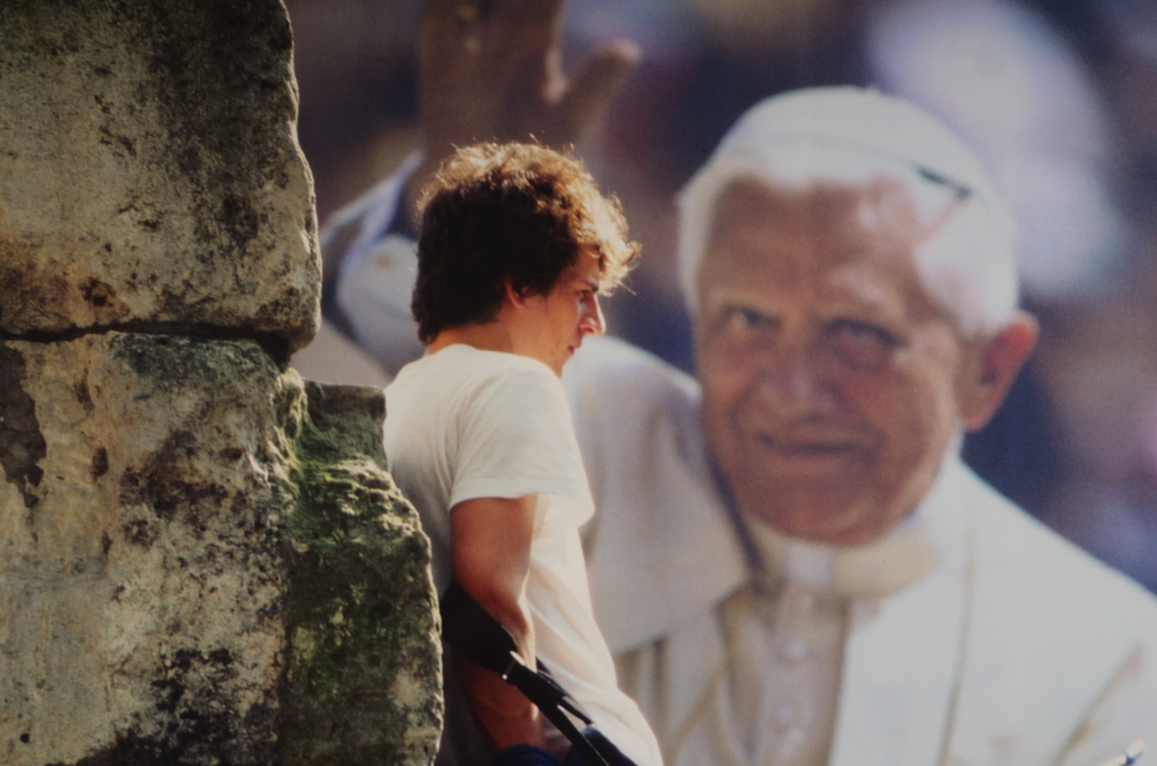 Jugendlicher vor Riesenposter von Papst Benedikt XVI