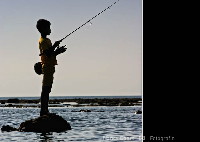 Junge beim Fischen auf Bali