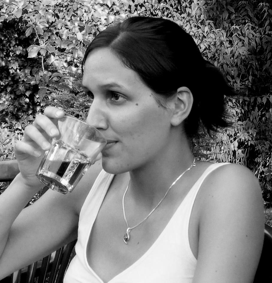 Junge Frau - trinkend - vor Waldrand am Abend