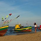 Junge Frau und Fischerboote an der polnischen Ostseeküste