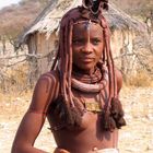 Junge Himbafrau vor ihrer Hütte