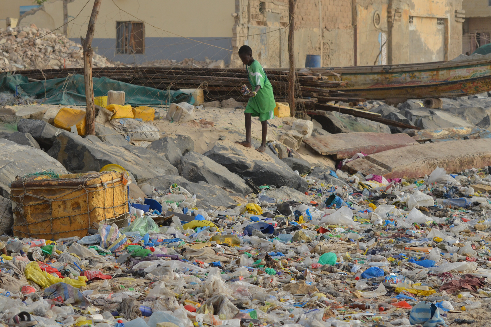 Junge vor den Müllbergen des Strandes von Guet Nadar (St. Louis, Senegal)