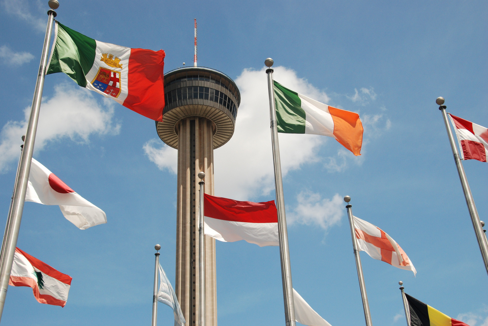 Juxtaposition of Tower Of The Americas in San Antonio, Tx. and all flags flown in Texas.