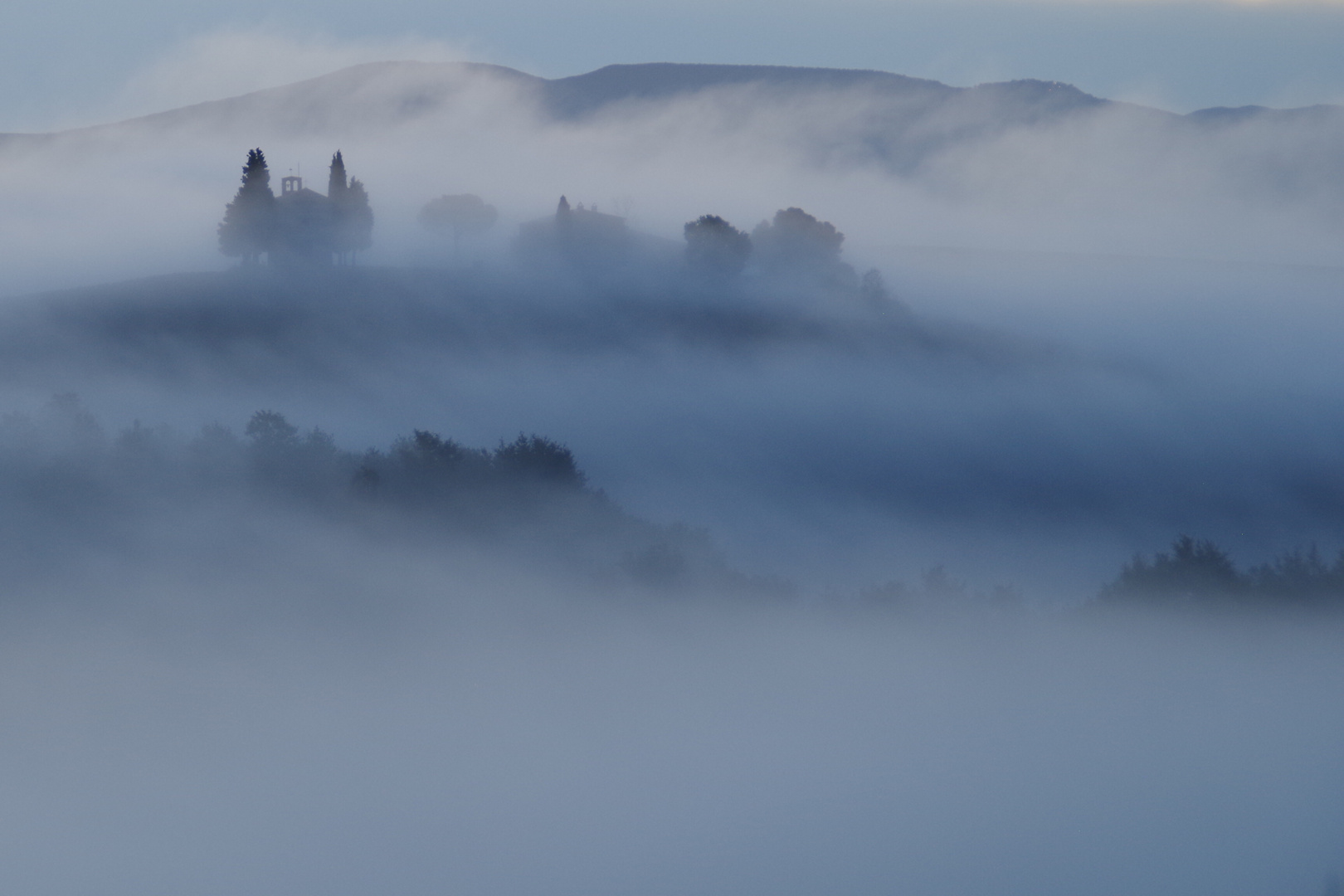 Kapelle im Val d' Orcia früh morgens im Nebel