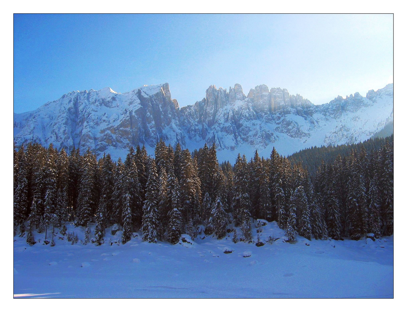 Karersee im Winter mit Latemar im Hintergrund