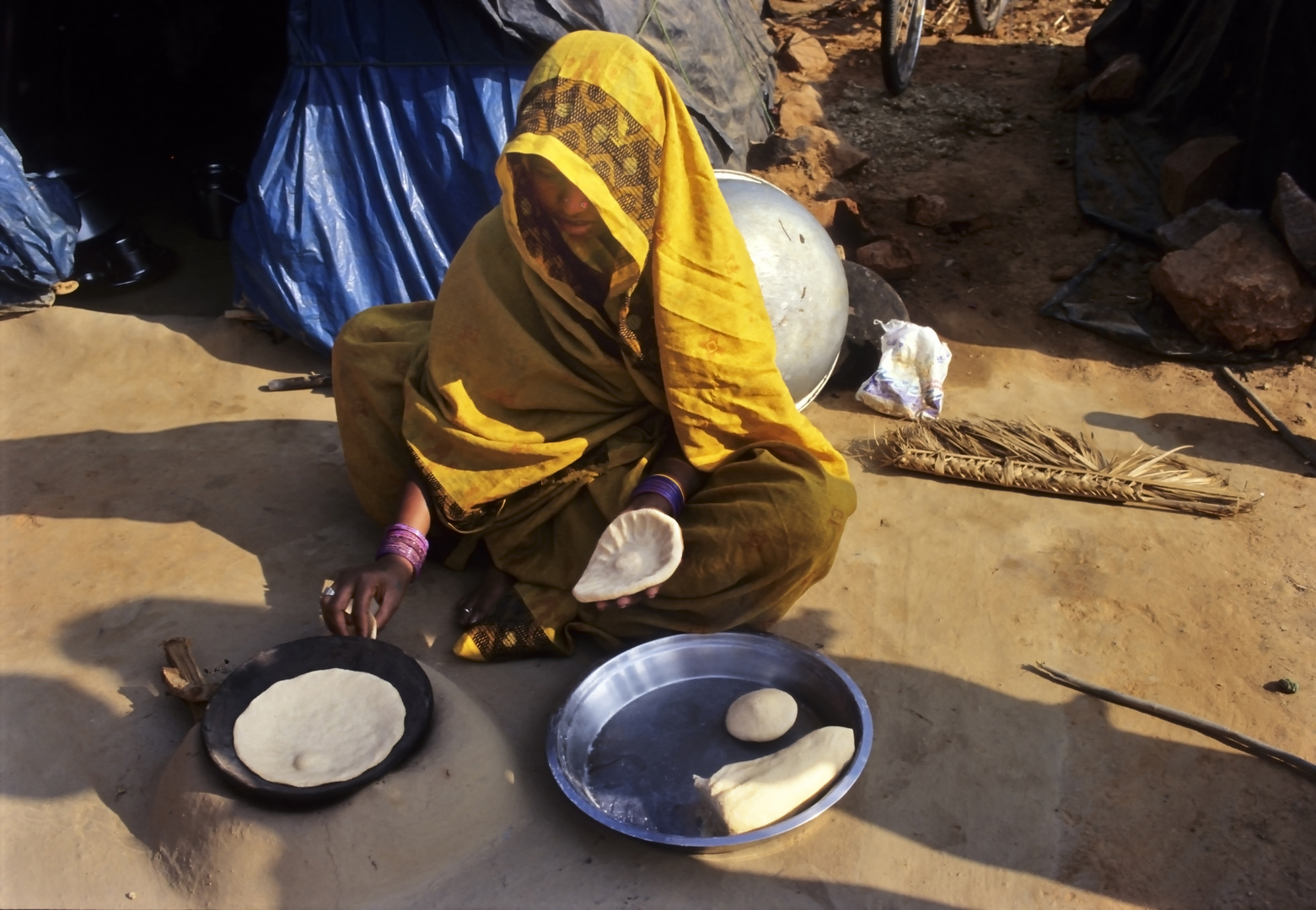 Khajuraho - Mutter beim backen der Brote - meistens die Hauptmahlzeit