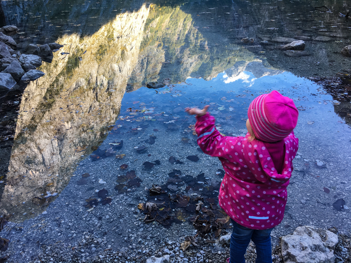 Kind begeistert über Spiegelung im See