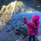 Kind begeistert über Spiegelung im See