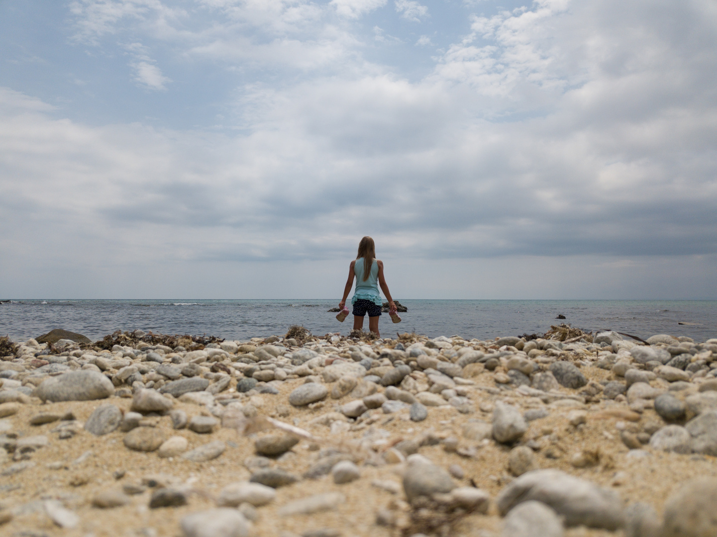 Kind guckt verträumt auf das Meer