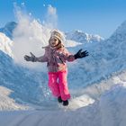 Kind im Schnee vor Alpenpanorama