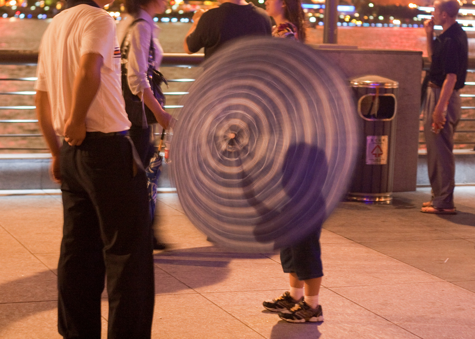 Kind in Shanghai spielt mit Regenschirm