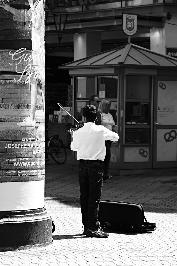 Kind mit Geige macht Straßenmusik in Nürnberg