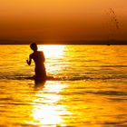 Kinder im Wasser bei Sonnenuntergang