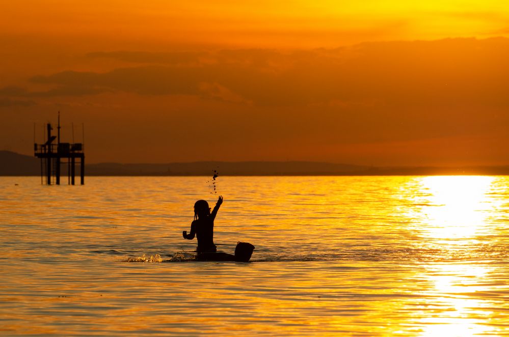 Kinder im Wasser Sonnenuntergang
