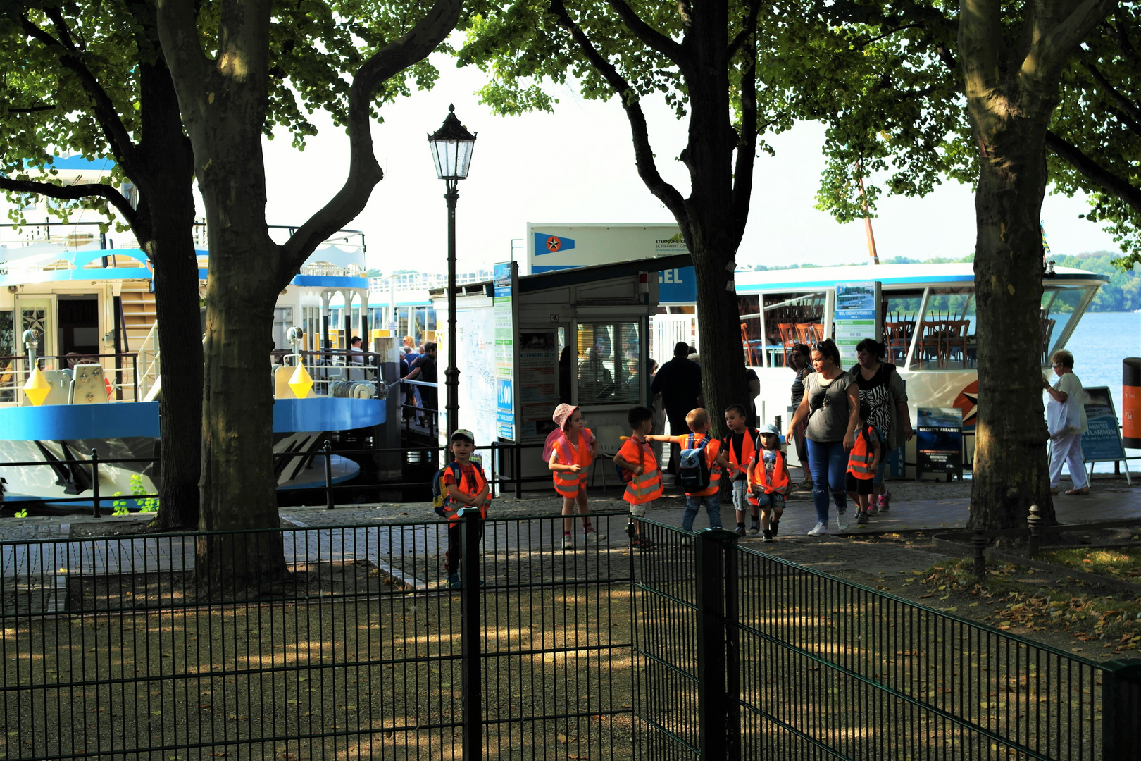 Kinder kommen zum Spielplatz (eingezäunt) direkt an der Anlegestelle Fahrgastschiffe