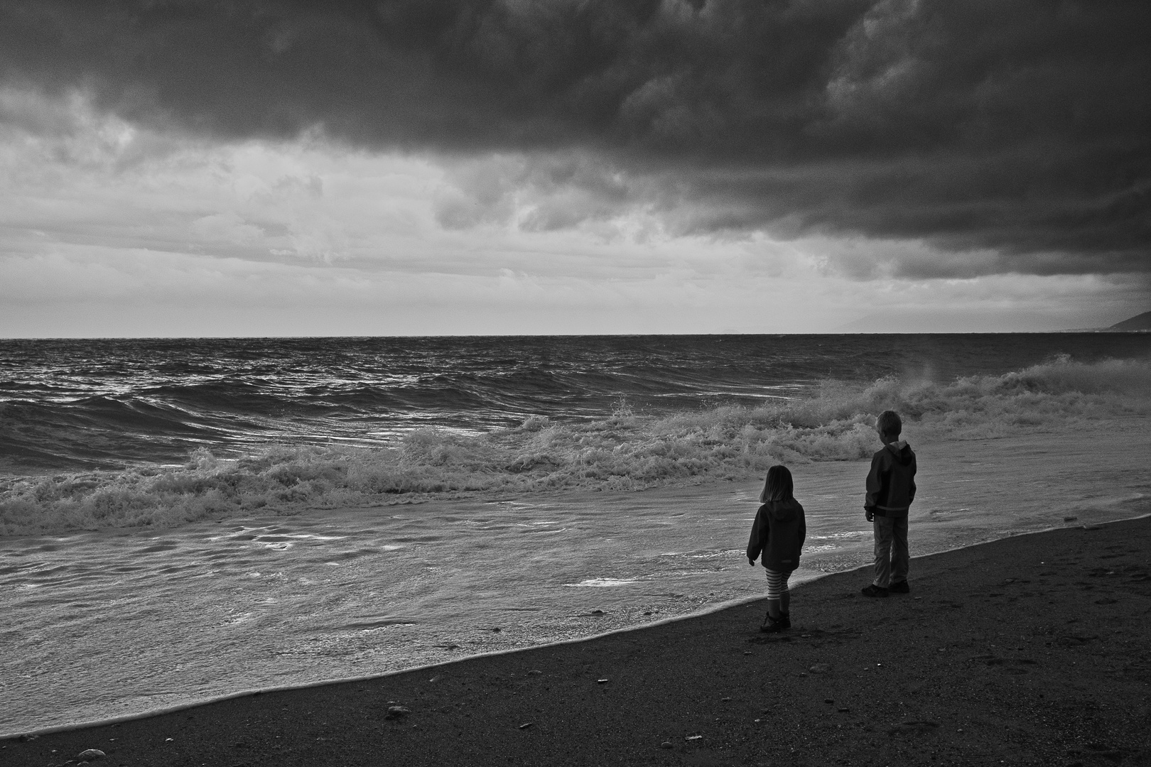 Kinder staunen am stuermischen Meer