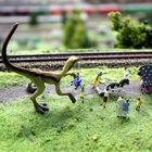 KInderausflug und der Dino trägt einen vergessenen  Puppewagen hinterdrein