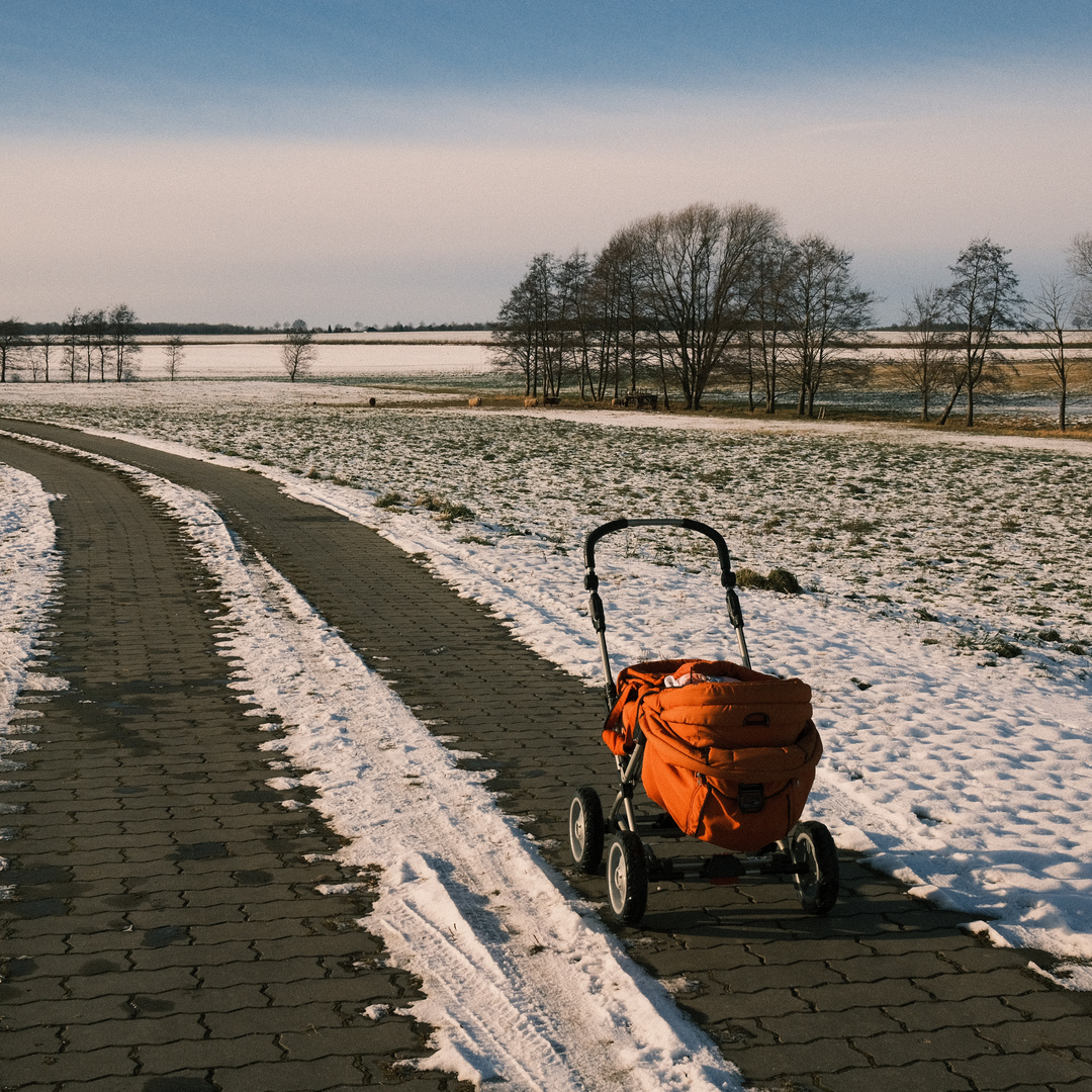 Kinderwagen in Schnee und Sonne 