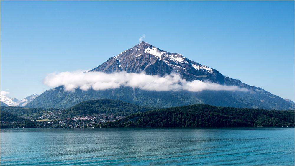 Kindlicher Berg mit Wolke und Wölkchen am Gipfel