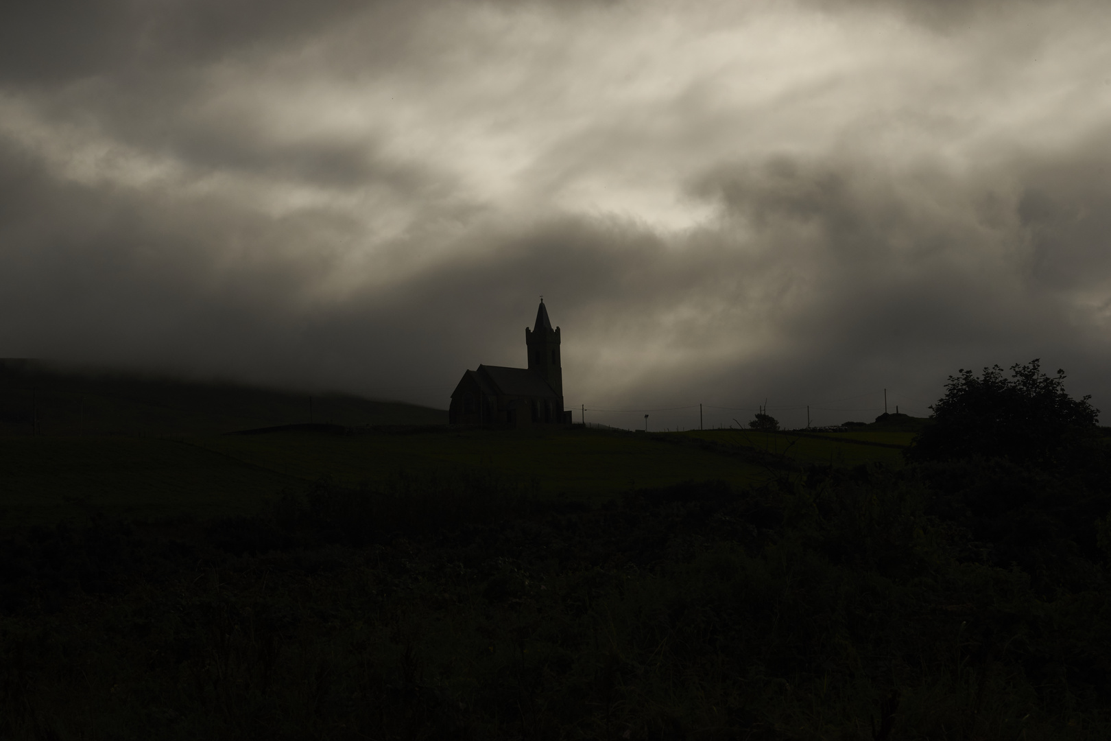 Kirche von Glenkolumbkille in den Wolken versunken.