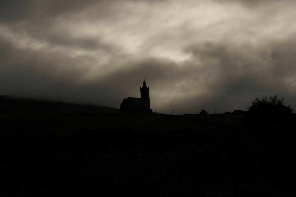 Kirche von Glenkolumbkille in den Wolken versunken.