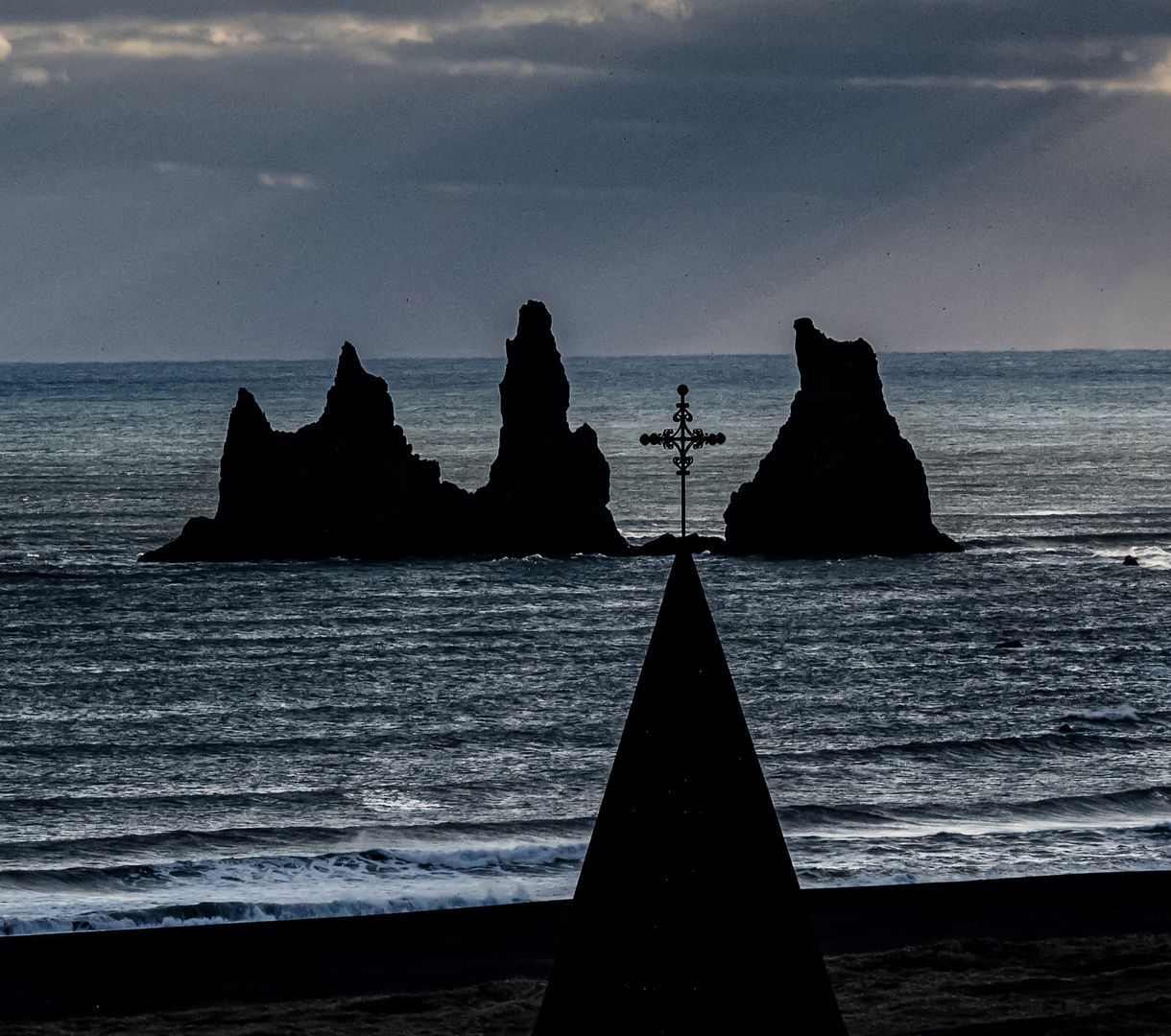 Kirchenkreuz und Felsen im Meer