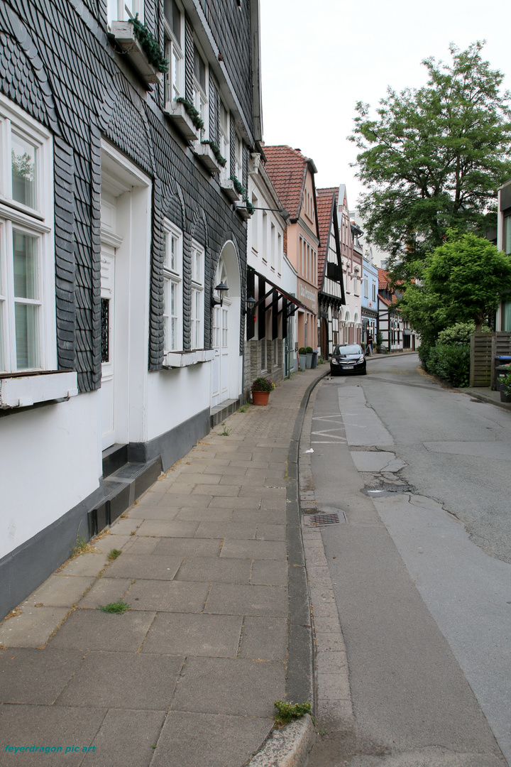 kleine gasse schiefe häuser 