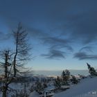 Kleine Wolkenpölster über der schneebedeckten Landschaft