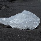 Kleiner Eisbrocken am schwarzen Strand von Jökulsa