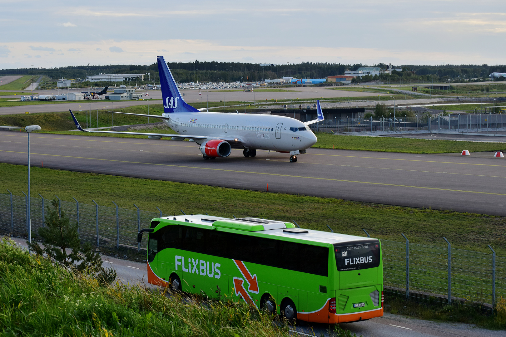 Kleiner FlixBUS trifft auf große Boeing 737-783.