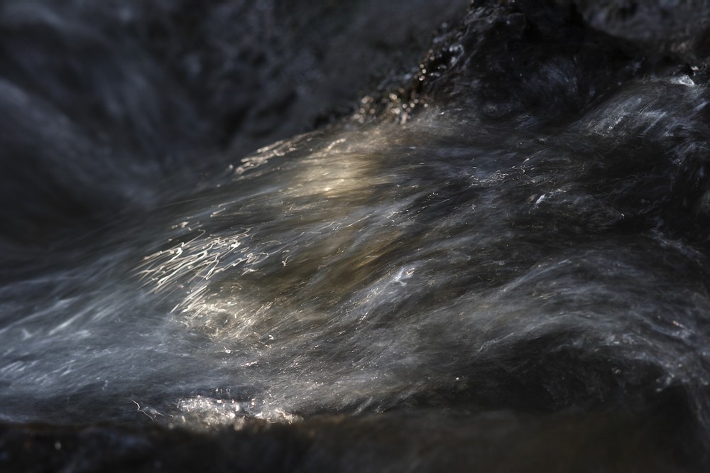 Kleiner Wasserfall im Sonnenlicht