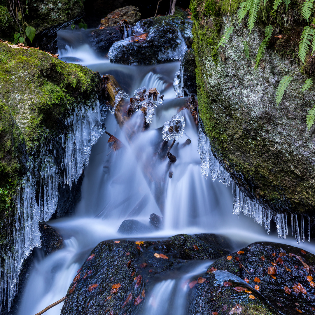 Kleiner Wasserfall mit Eis und Holz