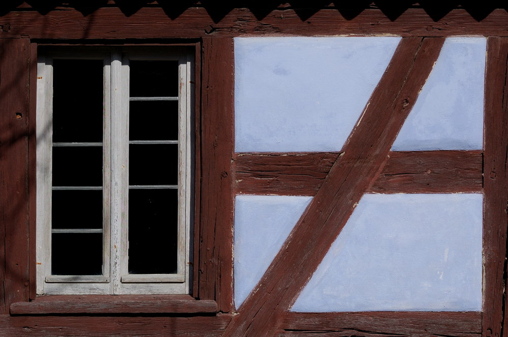 kleines Fenster mit Fachwerk, Detail eines alten Bauernhofs