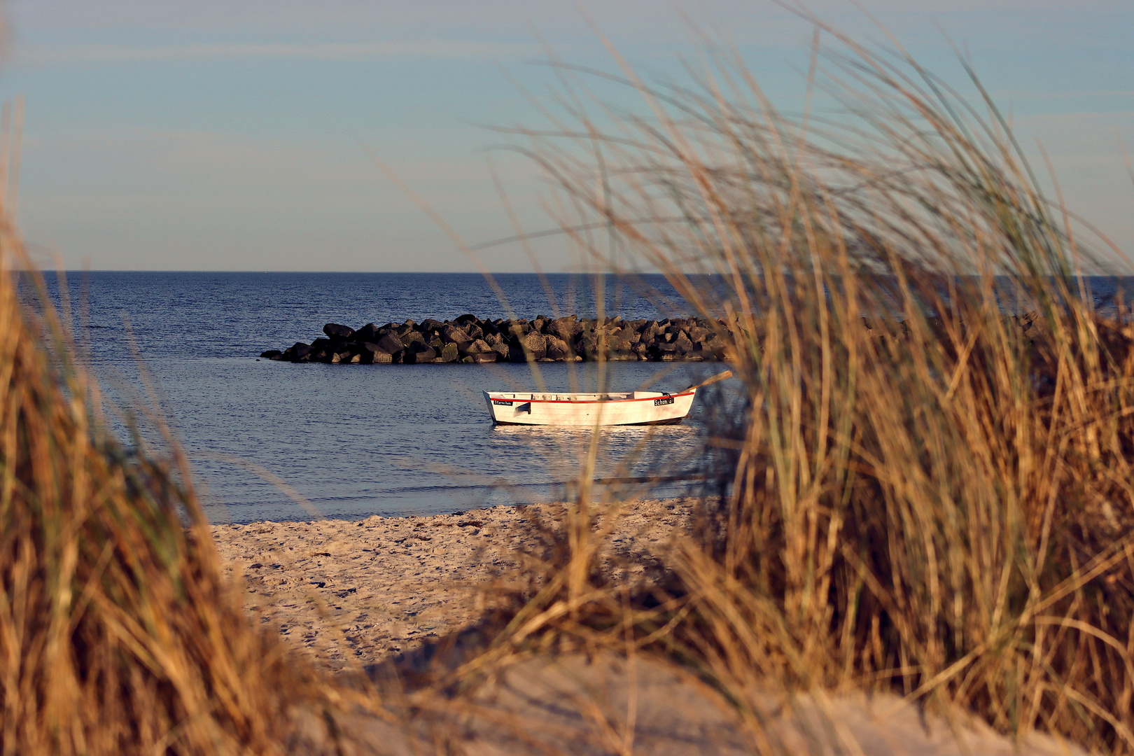 Kleines Fischerboot vor Anker am Strand